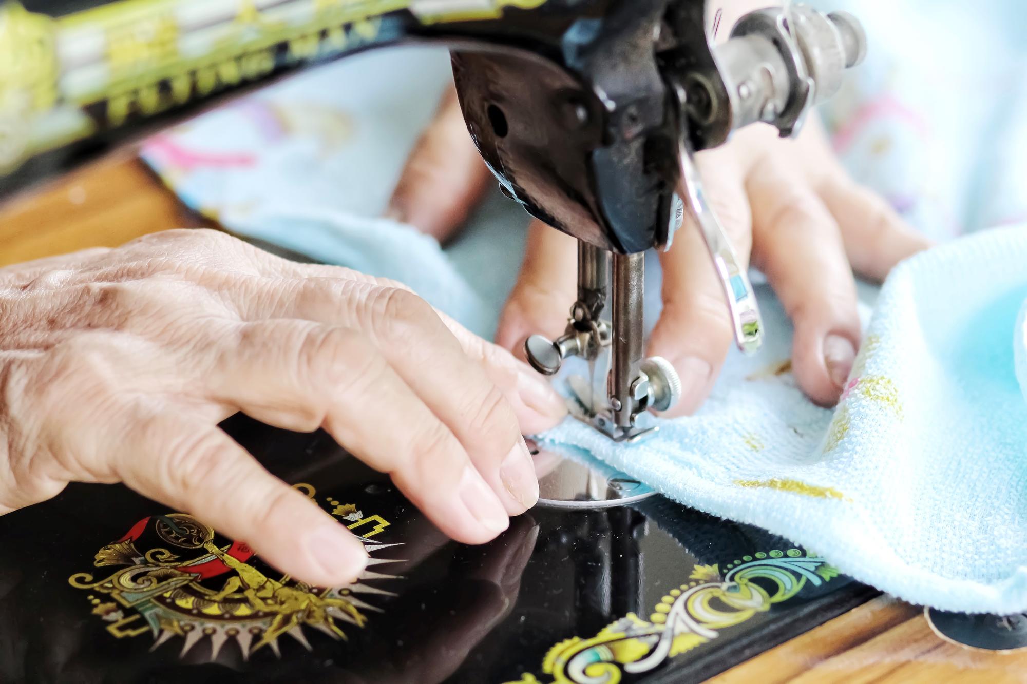 Hand and machine collaborating on embroidered jacket